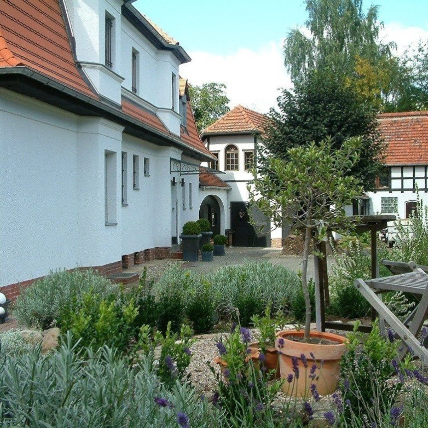 Der Hof mit blühendem Lavendel vor dem weißen Haupthaus